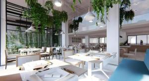 a restaurant with white tables and chairs and plants at Thaisun Bangkok Hotel in Bangkok