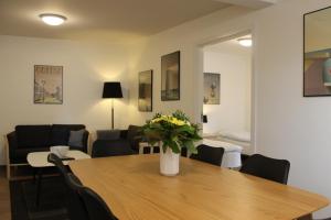 a dining room with a table with a vase of flowers on it at Amalie Bed and Breakfast & Apartments in Odense