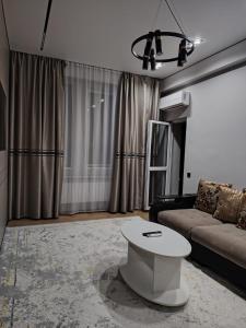 un salon avec un canapé et une table dans l'établissement 24 home Aktau, à Aktau
