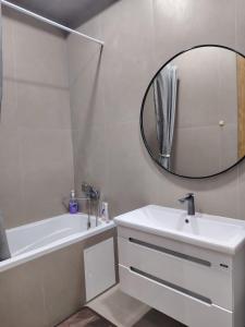 une salle de bain blanche avec un lavabo et un miroir dans l'établissement 24 home Aktau, à Aktau