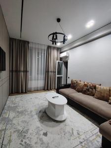 un salon avec un canapé et une table dans l'établissement 24 home Aktau, à Aktau
