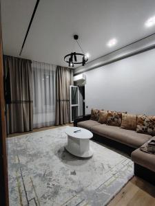 un salon avec un canapé et une table dans l'établissement 24 home Aktau, à Aktau