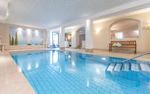 una gran piscina en una casa con una gran piscina en Hotel Zirmerhof & Residence, en Rifiano