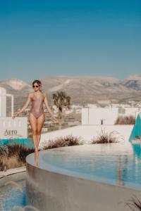 a woman in a bikini standing in a swimming pool at Niléa Island Living in Agia Anna Naxos