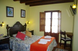 Narciandi的住宿－Balcón Picos de Europa，一间卧室配有一张床、一张书桌和一个窗户。