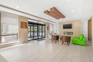 an office lobby with a green couch and a tv at Country Inn & Suites by Radisson, Staten Island in Staten Island