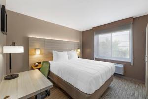 a hotel room with a large bed and a desk at Country Inn & Suites by Radisson, Staten Island in Staten Island +23 photos