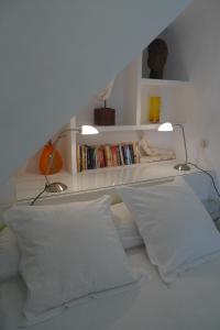 グラナダにあるAlhambra Hill Apartmentsのベッドルーム1室(白い枕とランプ2つ付)