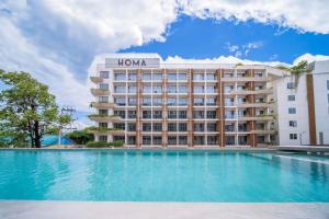 a hotel with a swimming pool in front of a building at 2Bdr Cozy Apartment in heart of BangTao in Ban Thalat Choeng Thale