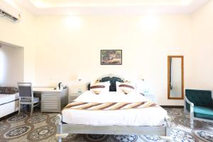 a bedroom with a bed and a desk and chairs at Sajjan Jawai Chapter by Arow Hospitality in Mori Bera