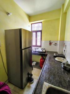 Il comprend une cuisine équipée d'un grand réfrigérateur en acier inoxydable. dans l'établissement Luxury Retreat 3 BHK Flat For Family and Group Homestay, Prime Location Near Kashi Vishwanath Temple, à Varanasi