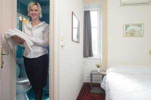 a woman is standing in a hotel room holding a towel at Konstantinoupolis in Corfu