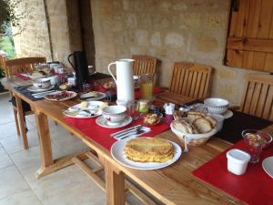 a wooden table with breakfast foods on it at Entre Lot et Dordogne in Saint-Cirq-Madelon +14 photos