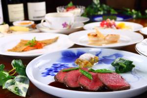 ein Tisch mit Tellern voller Essen auf einem Tisch in der Unterkunft Auberge Licht in Hita