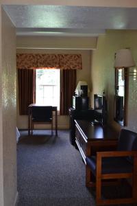 a hotel room with a desk and a living room at Americas Best Value Inn Smithfield in Smithfield