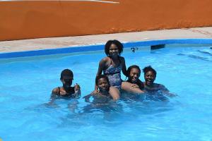 kobieta stojąca w basenie z grupą dzieci w obiekcie Americas Best Value Inn Smithfield w mieście Smithfield