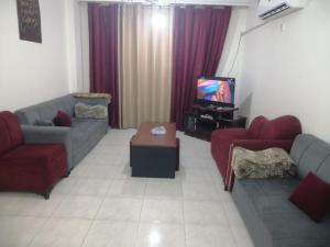 a living room with two couches and a tv at ميرا للشقق المفروشة Mera Apartment in Aqaba