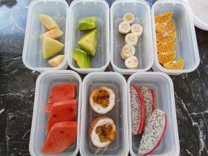 four plastic containers filled with different fruits and vegetables at Private Lodge Beachside Samui Lamai in Lamai