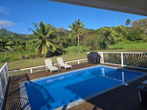 a swimming pool on a deck with two chairs next to it at T&T Retreat in Matavera