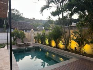 une piscine dans l'arrière-cour d'une maison dans l'établissement Villa Vindo - 1BR & Swimming pool, à Kuta Lombok 8 autres photos