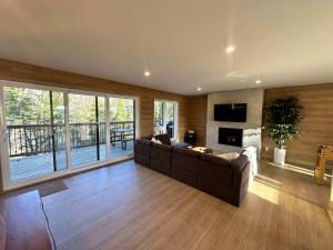 een grote woonkamer met een bank en een televisie bij Foosball table Spa & Sauna - Sommetoile in Saint Come