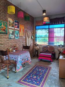 une pièce avec une table et des chaises et un mur de briques dans l'établissement Moonrise Cottage Private Country Home with Moutain View, à Thung Yao