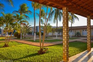 Una pasarela de madera con palmeras en un parque en Fiesta Bahiana Club Hotel, en Irecê