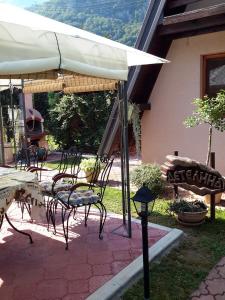 un patio con mesa, sillas y sombrilla en Viola i Detelina Apartments, en Perućac