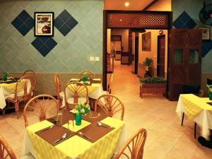 a restaurant with tables and chairs with yellow table cloth at Hua Hin Loft Managed by Loft Group in Hua Hin
