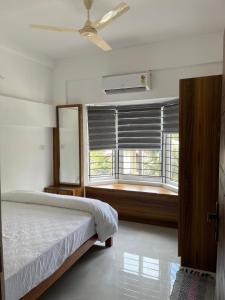 a bedroom with a bed and a window with blinds at Enhance Lifestyle Service Apartments in Thamarassery