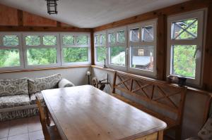 un soggiorno con tavolo in legno e finestre di Noclegi Dywan a Dywan