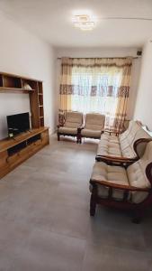 a living room with two chairs and a television at HighlandRose Heaven Peace near Tribeca mall in Hermitage