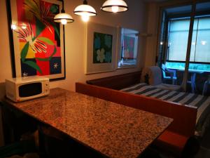 a room with a bed and a microwave on a table at Punta Ala - Monolocale Vista Mare 4 P - Bilocale 5 P - Monolocale 4 P in Punta Ala
