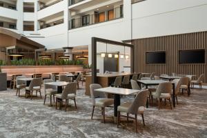 a restaurant with tables and chairs in a building at Embassy Suites by Hilton at Hot Springs Convention Center in Hot Springs