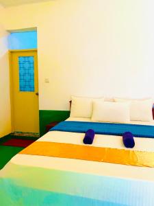 阿鲁甘湾Marina Village的一间卧室配有一张带彩色床单的大床