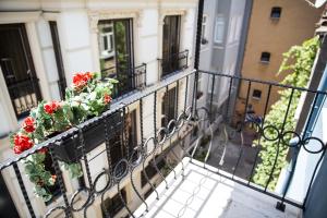 a balcony with red flowers on a building at Ditto Flats in Istanbul