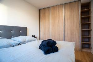a bedroom with a bed with black towels on it at Luxapartment ll Krivá in Košice