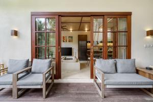 a living room with two chairs and a television at Exclusive townhouse Beachside Excellent location in Sanur