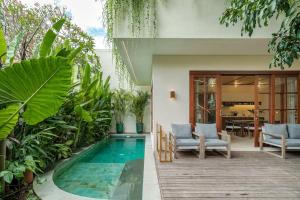 a house with a swimming pool in a garden at Exclusive townhouse Beachside Excellent location in Sanur