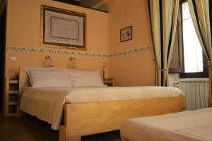 a bedroom with two beds and a window at Bed & Breakfast l'Albergo Di Ieri in Serravalle di Chienti