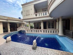 a house with a swimming pool in front of a house at Vila Princess Sentul 7 bedroom Private pool, Billiard, Tenis meja in Babakan Madang