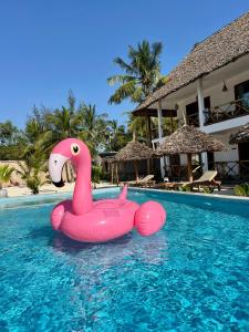 a pink swan float in a pool at a resort at Pamoja Villas in Migogoni