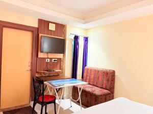 Una habitación con una silla, una mesa y un televisor. en Hotel Sea View Residency Near Sea Beach - Near Light House ! Sea Beach - Swargadwar Golden Beach -Fully Air Conditioning Luxuray Rooms ! BEST HOTEL I, en Cuttack