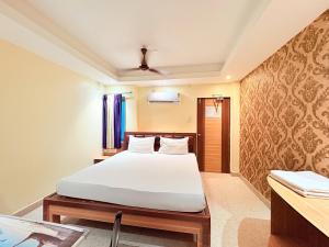 Un dormitorio con una cama blanca y un escritorio. en Hotel Sea View Residency Near Sea Beach - Near Light House ! Sea Beach - Swargadwar Golden Beach -Fully Air Conditioning Luxuray Rooms ! BEST HOTEL I, en Cuttack