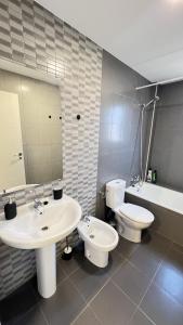 a bathroom with two sinks and a toilet and a mirror at Apartamenticos Living San Pablo in Zaragoza +61 photos