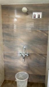 a bathroom with a metal sink and a bucket at New White House Hotel in Pune