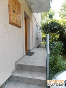 a stairway leading up to a building with a door at Herbert Apartman in Bük