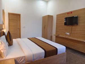 une chambre avec un lit et une télévision à écran plat dans l'établissement Hotel Devi Ram Atithi Bhawan Near Prem Mandir, à Vrindavan