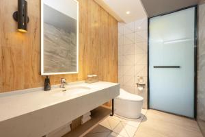 a bathroom with a sink and a toilet at Jin Yi Youxuan Hotel Baotou Wanda Plaza Branch in Baotou