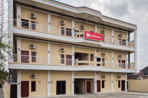 ein Gebäude mit einem roten Schild darauf in der Unterkunft RedDoorz at Risma Hostel ITERA Lampung in Kedaton